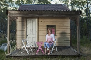 Denise sitting on the verandah of her small home